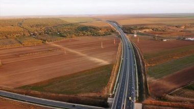 Hareket halindeki arabaların diğer yoldan geçtiği Güneş Otoyolu, etrafındaki tarlalar. İnsansız hava aracının görüntüsü. Romanya