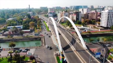 BUCHAREST, ROMANIA - 18 Ekim 2020: Grozavesti köprüsü bir kanalı geçiyor, hareket halindeki arabalar, modern ticari ve konut binaları, yeşillik. İnsansız hava aracından görüntüle