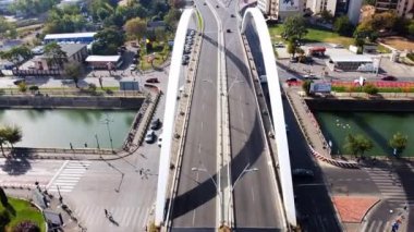 BÜKREŞ, ROMANIA - 18 Ekim 2020: Grozavesti köprüsü bir kanalı geçiyor, hareket halindeki arabalar, modern ticari ve konut binaları, yeşillik ve park yeri. İnsansız hava aracından görüntüle