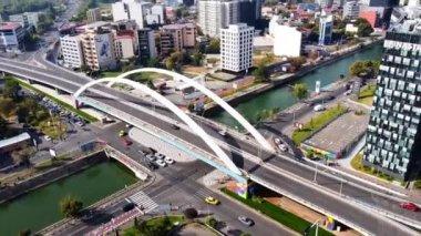 BÜKREŞ, ROMANIA - 18 Ekim 2020: Grozavesti köprüsü bir kanalı geçiyor, hareket halindeki arabalar, modern ticari ve konut binaları, yeşillik ve park yeri. İnsansız hava aracından görüntüle