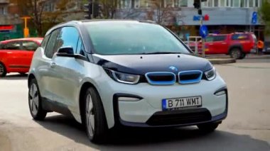 BUCHAREST, ROMANIA - 20 Ekim 2020: modern BMW i3 elektrikli araba şehir merkezinde yolda gidiyor. Sıfır emisyon aracının yakın görüntüsü. Ekoloji fikri