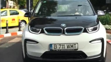 BUCHAREST, ROMANIA - 20 Ekim 2020: modern BMW i3 elektrikli araba şehir merkezinde yolda gidiyor. Sıfır emisyon aracının yakın görüntüsü. Ekoloji fikri