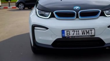 BUCHAREST, ROMANIA - 20 Ekim 2020: Modern BMW i3 elektrikli araba kavşakta dönüyor. Küçük sıfır emisyon aracı. Ekoloji fikri
