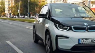 BUCHAREST, ROMANIA - 20 Ekim 2020: modern BMW i3 elektrikli araba şehir merkezinde yolda gidiyor. Sıfır emisyon aracının yakın görüntüsü. Ekoloji fikri