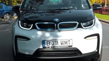 BUCHAREST, ROMANIA - 20 Ekim 2020: modern BMW i3 elektrikli araba şehir merkezinde yolda gidiyor. Sıfır emisyon aracının yakın görüntüsü. Ekoloji fikri