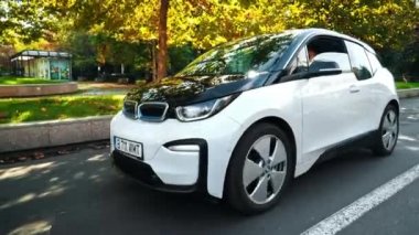 BUCHAREST, ROMANIA - 20 Ekim 2020: Modern BMW i3 elektrikli araba şehir merkezindeki yaya geçidinin yanında yeşil ışık bekliyor. Küçük sıfır emisyon aracı. Ekoloji fikri