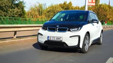BUCHAREST, ROMANIA - 20 Ekim 2020: modern BMW i3 elektrikli araba şehir merkezinde yolda gidiyor. Sıfır emisyon aracının yakın görüntüsü. Ekoloji fikri