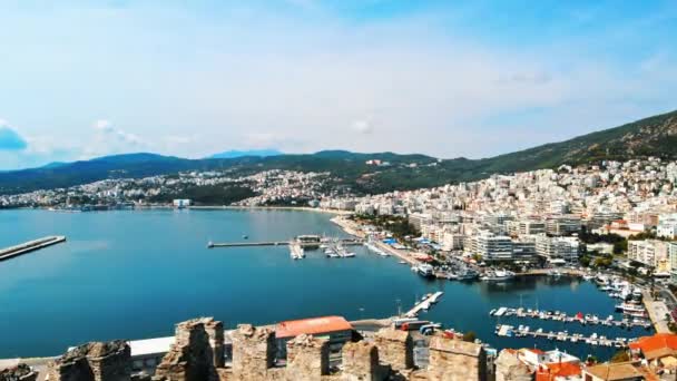 Aerial view of Kavala, a lot of buildings, Aegean sea coast, green hills in the distance. Drone flies out from behind the wall of ancient fort. Greece — Stock Video