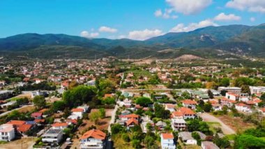 Asprovalta Panoraması 'nda birden fazla bina ve yeşillik var, arka planda yeşil tepeler. Ege kıyısı. Güneşli bir gün. Yunanistan