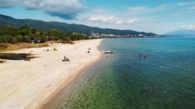 Asprovalta Panorama 'sı, yeşillik, arka planda yeşil tepeler. Ege kıyısı. Kasaba boyunca uzun bir sahil. Dinlenen insanlar. Güneşli bir gün. Yunanistan