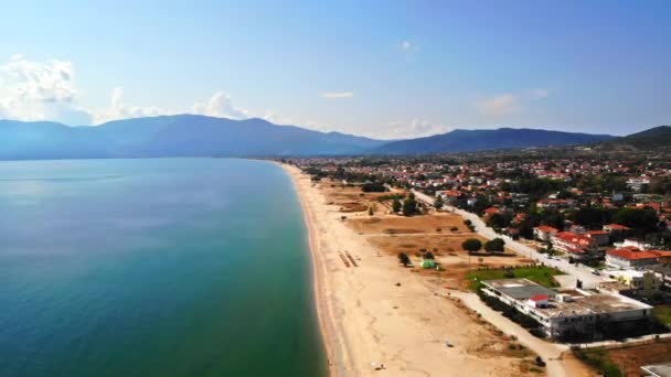 Panorama da Asprovalta com vários edifícios e vegetação, colinas verdes no fundo. Costa do mar Egeu. Longa praia ao longo da cidade. Dia ensolarado. Grécia — Vídeo de Stock
