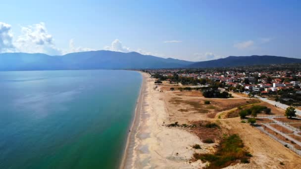 Panorama der Asprovalta mit mehreren Gebäuden und viel Grün, grüne Hügel im Hintergrund. Ägäis. Langer Strand entlang der Stadt. Sonniger Tag. Griechenland — Stockvideo