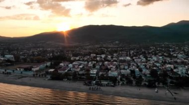 Asprovalta Panoraması 'nda birden fazla bina ve yeşillik var, arka planda yeşil tepeler. Ege kıyısı. Gün batımı. Yunanistan