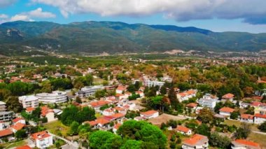 Asprovalta Panoraması 'nda birden fazla bina ve yeşillik var, arka planda yeşil tepeler. Ege kıyısı. Güneşli bir gün. Yunanistan