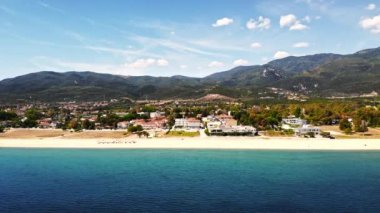 Asprovalta Panoraması 'nda birden fazla bina ve yeşillik var, arka planda yeşil tepeler. Ege kıyısı. Güneşli bir gün. Yunanistan