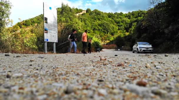 GRÉCIA, ASPROVALTA - 26 DE SETEMBRO DE 2020: Um casal com uma criança subindo as escadas de madeira para a estrada não pavimentada com um carro estacionado. Greenery em torno — Vídeo de Stock