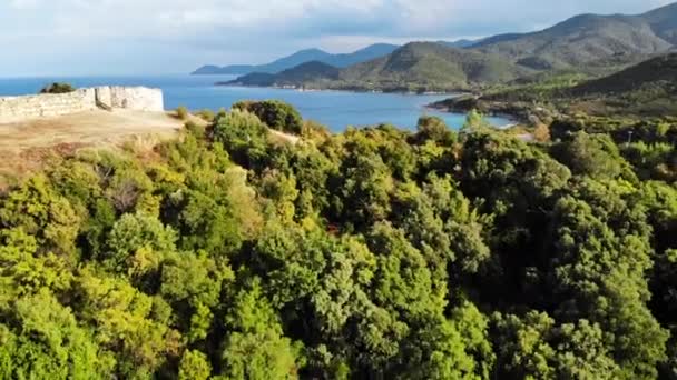 Collines couvertes de verdure luxuriante. Restes d'anciennes structures sur le sommet de la colline. Côte de mer Egée. Grèce — Video