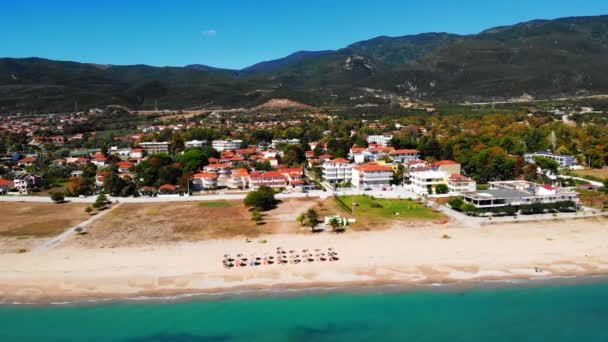 Vista de Asprovalta do drone. Edifícios e vegetação, longa praia ao longo da cidade. Água azul do mar Egeu. Colinas verdes em segundo plano. Grécia — Vídeo de Stock
