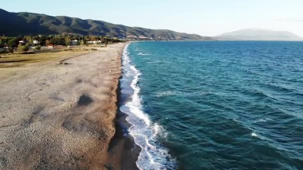 Vista della costa del Mar Egeo ad Asprovalta al tramonto dal drone. Gente sulla spiaggia. Mare mosso, onde con schiuma. Grecia — Video Stock