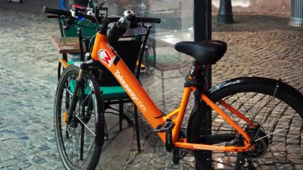 BUKARIUSZ, RUMUNIA - LISTOPAD 21, 2020: zaparkowany pomarańczowy rower z miejscami w kawiarni przy ulicy dla pieszych — Wideo stockowe
