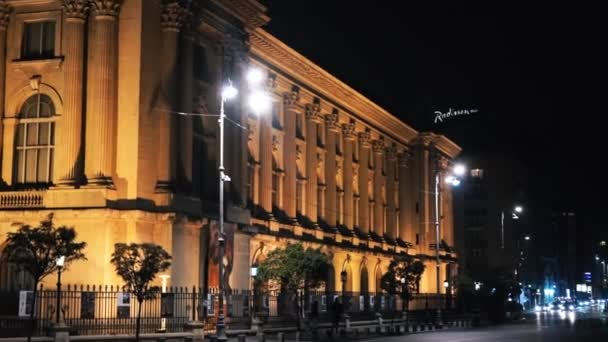 BUCHAREST, RUMANIA - 21 DE NOVIEMBRE DE 2020: Fachada de un edificio antiguo por la noche con luces nocturnas e iluminación, calle pn el primer plano — Vídeos de Stock