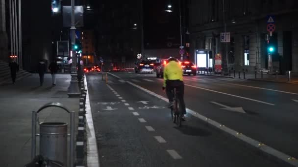 BUCHAREST, ROMANIA - 21 NOVEMBRE 2020: Paesaggio urbano di notte con pista ciclabile su strada, auto in movimento, persone sveglie e ciclisti in sella, illuminazione — Video Stock