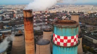 Gün batımında Bükreş 'te bir sürü tüp ve tesisi olan bir elektrik santrali. Tüpün içinden bir sürü köpük çıkıyor. Şehir manzarası, insansız hava aracı, Romanya