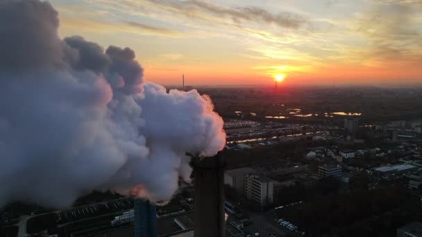 Central eléctrica con muchos tubos e instalaciones en Bucarest al atardecer, mucha espuma desde el interior de un tubo. Paisaje urbano, vista desde el dron volando a través de la espuma, Rumania — Vídeo de stock