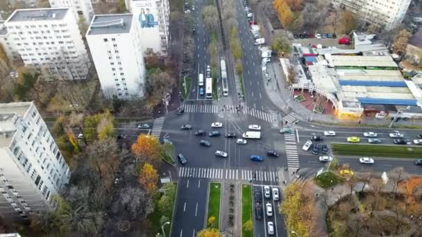 BUCHAREST, ROUMANIE - 9 DÉCEMBRE 2020 : Carrefour avec voitures en mouvement, personnes traversant la rue, tramways, arbres nus et bâtiments résidentiels, vue depuis un drone, panorama — Video
