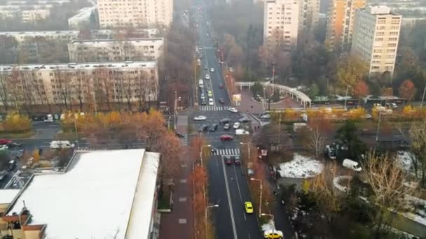 BUCHAREST, ROMANIA - 9 DICEMBRE 2020: Crocevia con macchine in movimento, persone che attraversano la strada, tram, alberi spogli ed edifici residenziali, vista da un drone, panorama — Video Stock