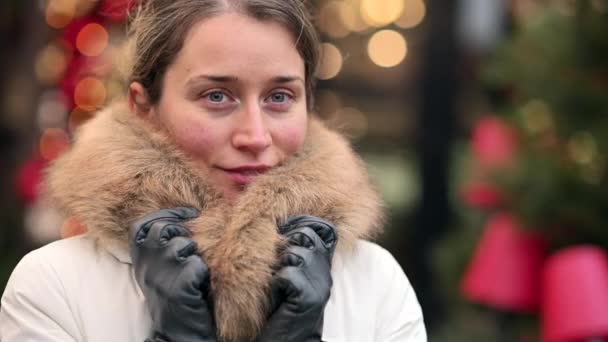 Vrouw Draagt Witte Winterjas Kerstmarkt Met Versieringen Glimlachend — Stockvideo