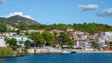 NEOS, GREECE - 8 ECTOBER 2020: Tepedeki yemyeşil binalarla Ege deniz kıyıları