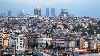 İSTANBUL, TURKEY - 21 Ekim 2020: Uzakta birçok düşük yerleşim ve yüksek modern bina, ön planda köprü ve bulutlu gökyüzü