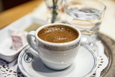 İSTANBUL, TURKEY - 21 Ekim 2020: Kafede bir fincan kahve, su, şeker ve çiçek