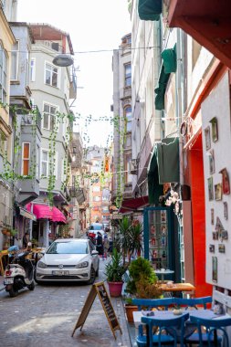 İSTANBUL, TURKEY - 21 Ekim 2020: İkamet binaları, yeşil süslemeler ve hareket halindeki arabalarla dar sokaklar
