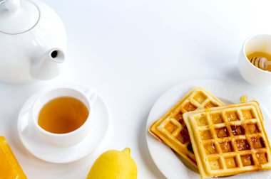 Kahvaltı ürünleri bileşimi. Waffle, çay ve limon. Beyaz arkaplan