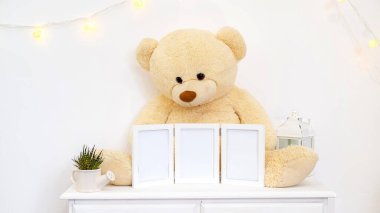 Oyuncak ayılı, çerçeveli ve mumlu beyaz ev dekorasyonları.