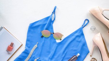 Masada kadın kıyafetleri, gözlükler, mavi elbise, ayakkabılar ve dekorasyon. Üst görünüm