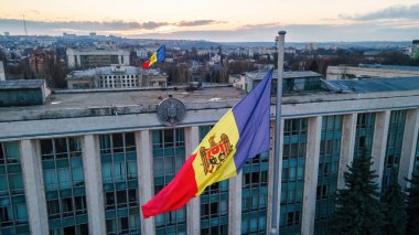 Gün batımında Hükümet Binası 'nın hava aracı görüntüsü. Arka planda bayrak ve birden fazla bina bulunan bina, Chisinau, Moldova 'da yangınlar
