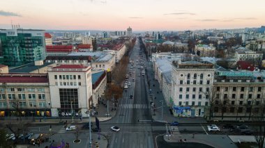 CHISINAU, MOLDOVA - 1 Ocak 2021: İHA şehir merkezi manzaralı, birden fazla binalı cadde, hareket halindeki arabalar ve çıplak ağaçlarla kaplı yol