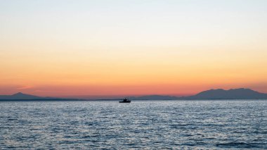 Ege Denizi 'nde gün batımı, uzakta gemi ve kara, su ve Yunanistan