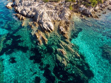 Kıyıya yakın kayalıkları ve mavi şeffaf suyun altındaki Ege kıyısı, Yunanistan insansız hava aracı manzaralı