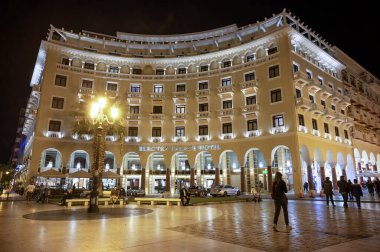 SALONIKI, GREECE - 26 Ekim 2020: Gece yarısı Electra Palace Oteli, birden fazla yürüyen insan ve park halindeki araçlar