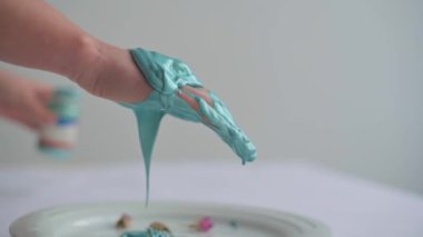 Kapalı kadın elleri turkuaz boyalarla oynuyor, yavaş çekim.