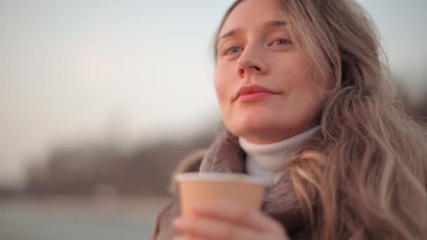 Glad leende kvinna dricker en kopp kaffe vid solnedgången — Stockvideo