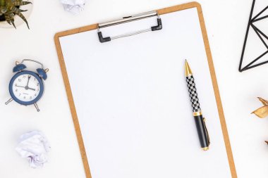 Yaşam tarzı kompozisyon. Üzerinde kağıt ve kalem olan not defteri, çalar saat. Üst görünüm