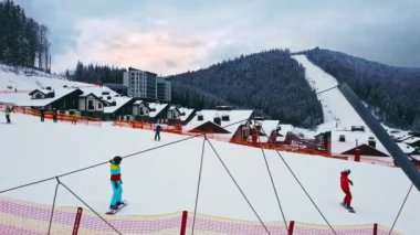 BUKOVEL, UKRAINE - 1 Şubat 2021: üzerinde insanlar olan kayak izleri. Dağlar, köknar ve karla kaplı evler. Kış