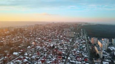 Chisinau 'nun güneş doğarken hava aracı görüntüsü. Birden fazla bina, yol ve çıplak ağaçların bulunduğu bir yerleşim bölgesi manzarası. Hava güzel, yerde kar var. Moldova