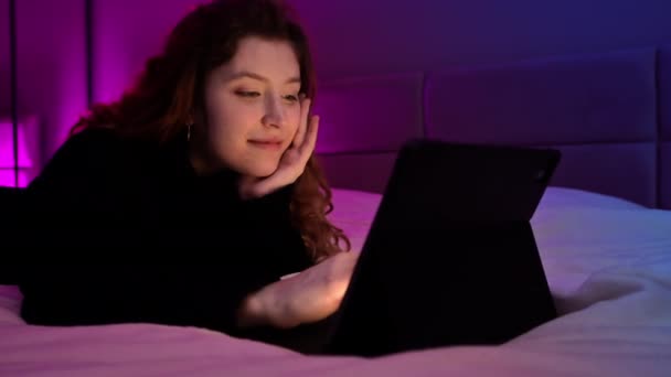 Een Jong Roodharig Meisje Bladert Nachts Door Haar Tablet Slaapkamer — Stockvideo