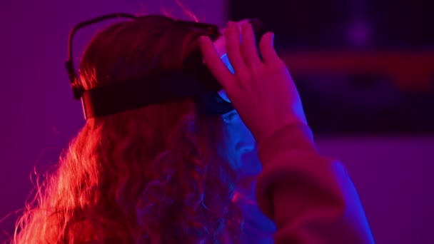 Девушка Рыжими Волосами Использующая Гарнитуру Виртуальной Реальности Яркими Неоновыми Огнями — стоковое видео